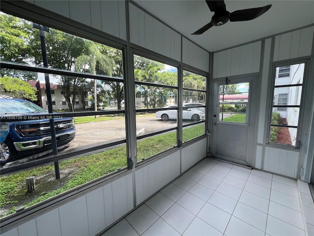 unfurnished sunroom with ceiling fan