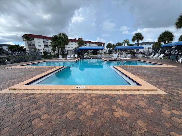 community pool featuring a patio area and fence