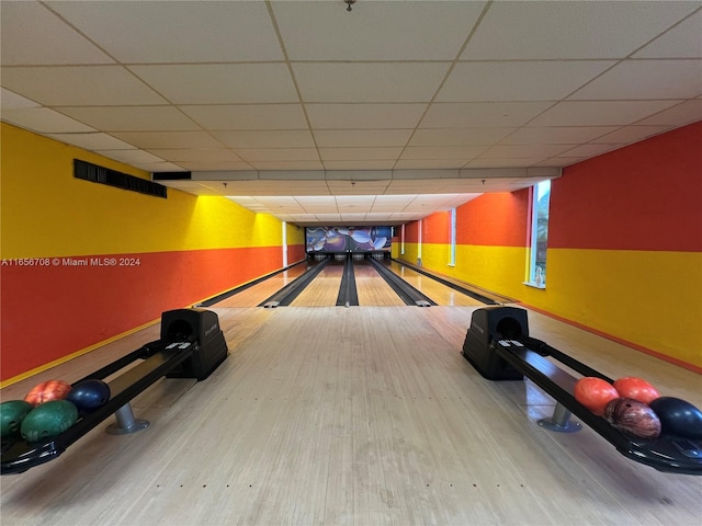 playroom featuring a bowling alley, hardwood / wood-style floors, and a drop ceiling