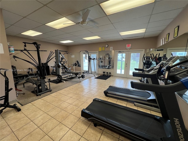 exercise room featuring french doors, ceiling fan, and a drop ceiling