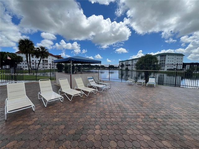 dock area featuring a water view, a gazebo, and a patio