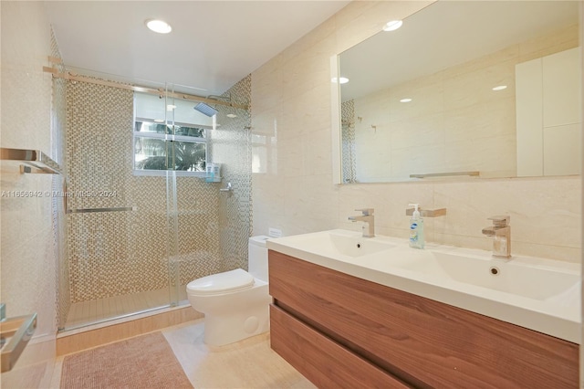 bathroom featuring toilet, walk in shower, tile patterned flooring, vanity, and tile walls