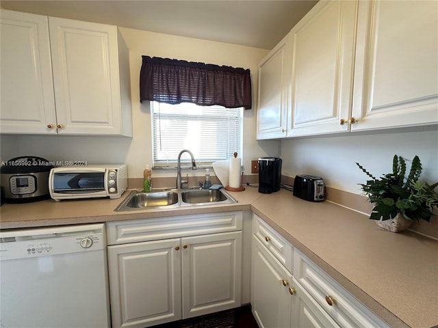 kitchen with dishwasher, white cabinetry, and sink