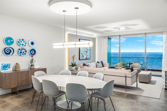 dining space featuring a water view and expansive windows