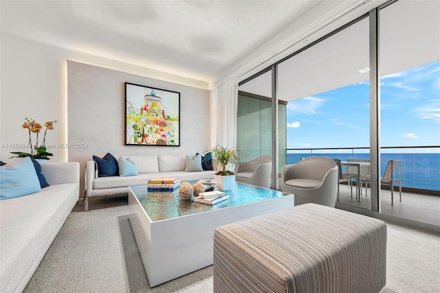 carpeted living room featuring a water view and floor to ceiling windows