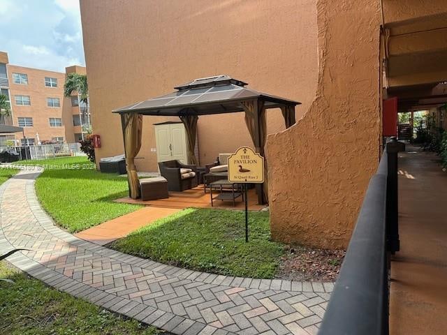 view of property's community with an outdoor hangout area, a lawn, and a gazebo