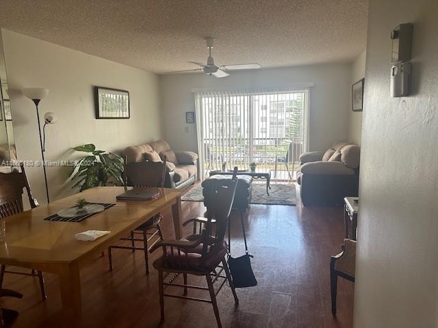 dining area with a textured ceiling, ceiling fan, and dark hardwood / wood-style flooring