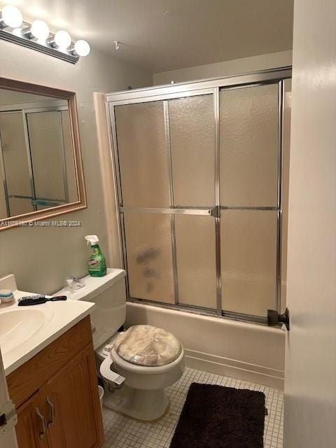 full bathroom featuring tile patterned floors, shower / bath combination with glass door, toilet, and vanity