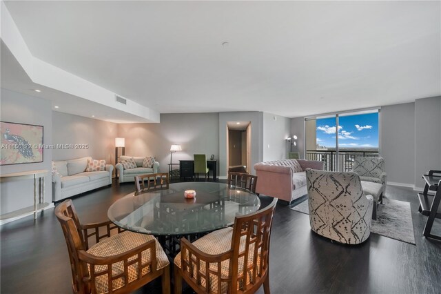 dining space featuring dark hardwood / wood-style floors and a wall of windows