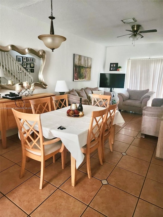 tiled dining area with ceiling fan