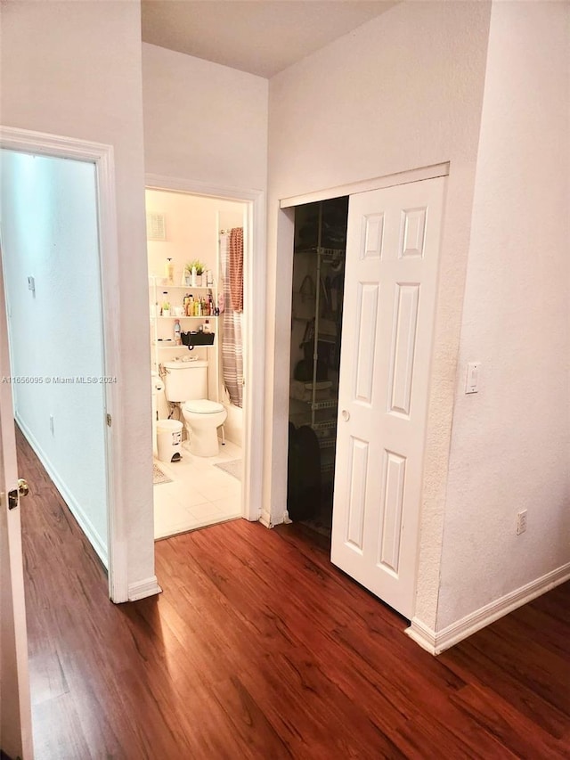 corridor with dark hardwood / wood-style flooring