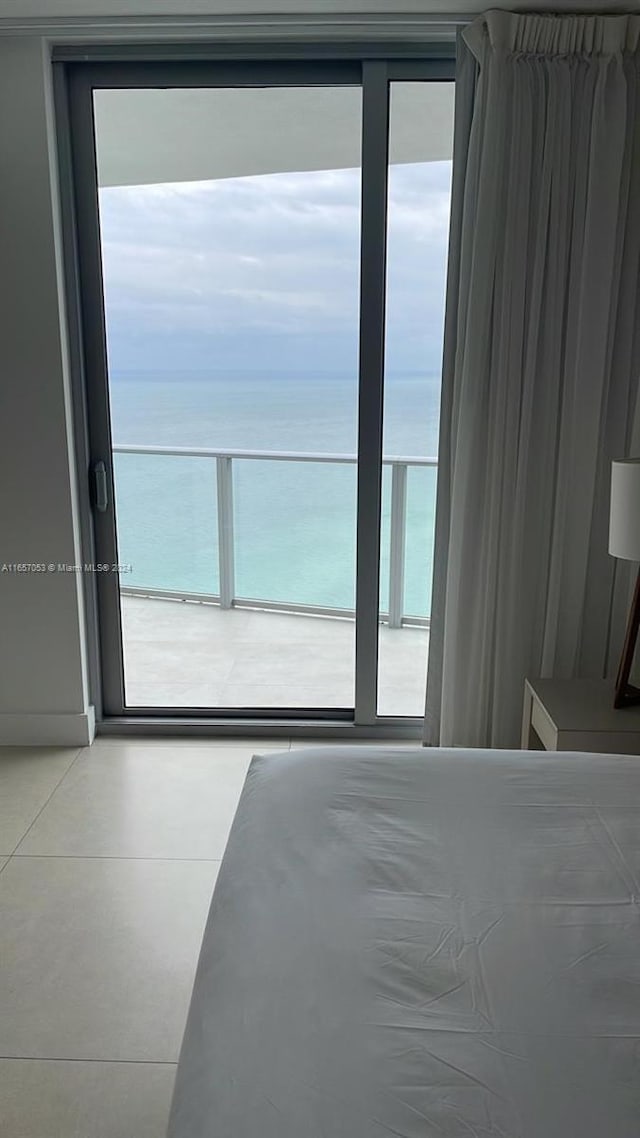 unfurnished bedroom featuring multiple windows, a beach view, and a water view