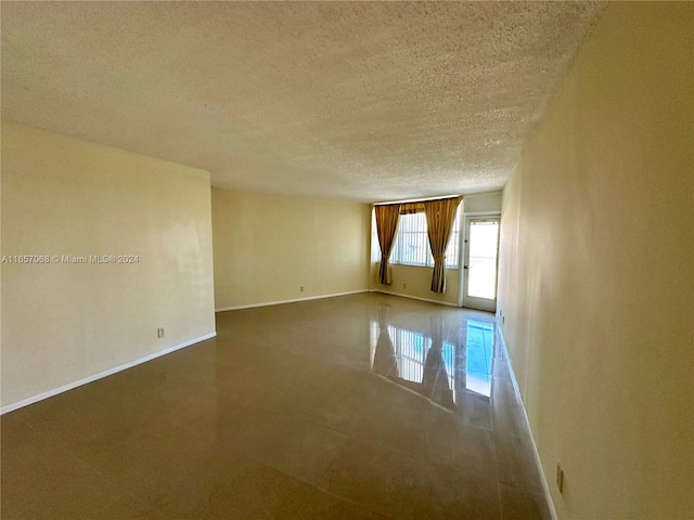 spare room with a textured ceiling