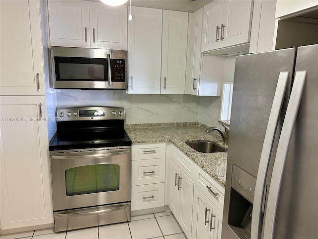 kitchen featuring white cabinets, sink, stainless steel appliances, and light tile patterned flooring