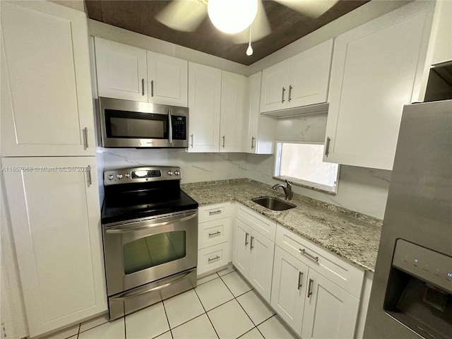 kitchen featuring light tile patterned flooring, light stone countertops, white cabinetry, and stainless steel appliances