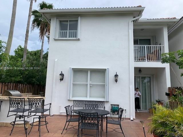 back of property with a balcony and a patio