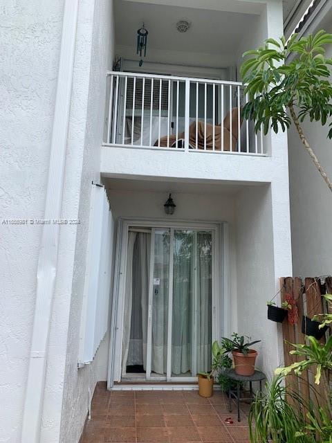 view of exterior entry featuring a balcony