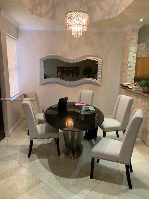 dining area featuring ornamental molding and an inviting chandelier