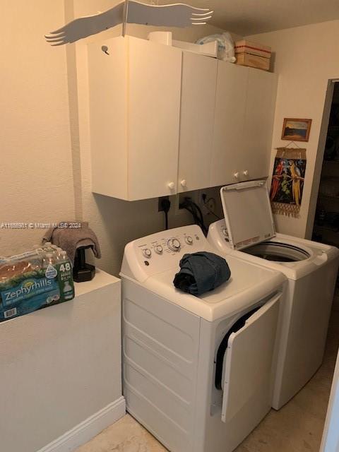 laundry area with cabinets and washer and clothes dryer