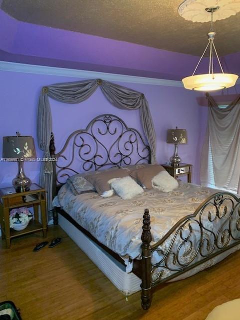 bedroom with hardwood / wood-style flooring and a textured ceiling