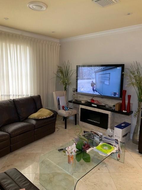 living room with crown molding and a wealth of natural light