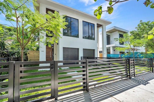 contemporary home featuring a fenced front yard, stucco siding, and an attached garage