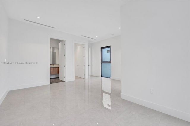 spare room featuring recessed lighting and baseboards