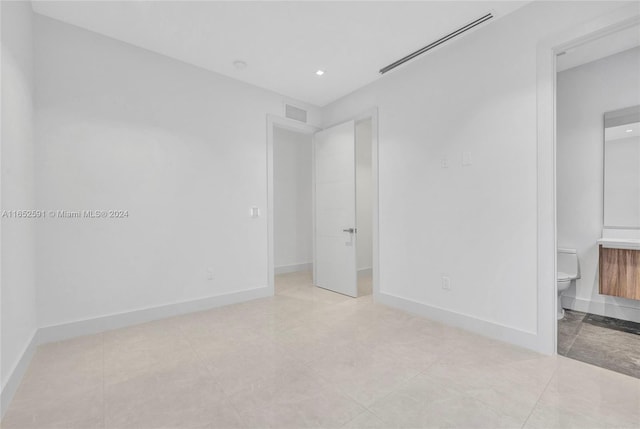 interior space with connected bathroom and light tile patterned floors