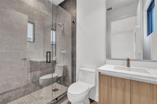 bathroom featuring vanity, toilet, and a shower with shower door