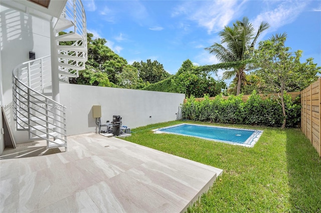 view of pool with a lawn, a patio, a fenced backyard, stairway, and a fenced in pool