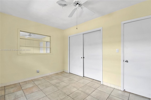 unfurnished bedroom featuring ceiling fan, light tile patterned floors, and a closet