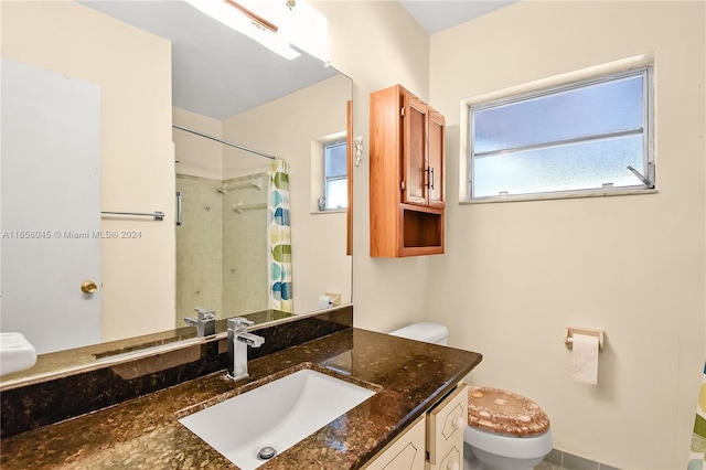 bathroom featuring vanity, toilet, a wealth of natural light, and curtained shower