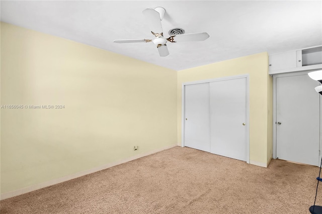 unfurnished bedroom featuring ceiling fan, light carpet, and a closet