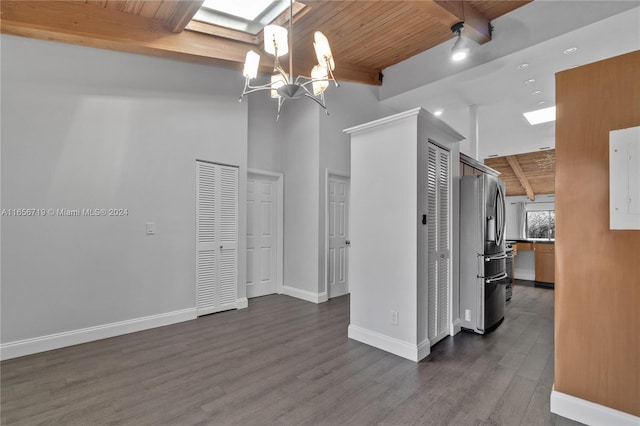 kitchen featuring dark wood-type flooring, stainless steel fridge, hanging light fixtures, and wooden ceiling