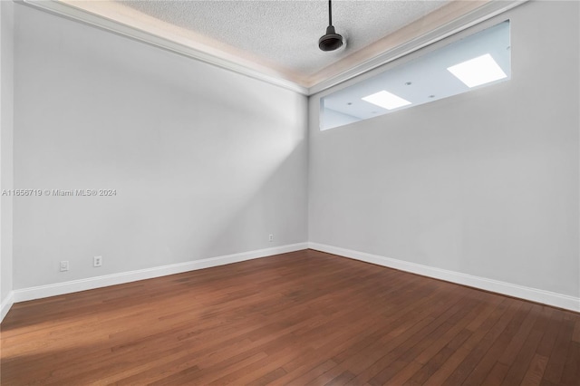 empty room with a textured ceiling and hardwood / wood-style flooring