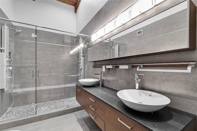 bathroom with vanity, a shower with shower door, and tile patterned floors