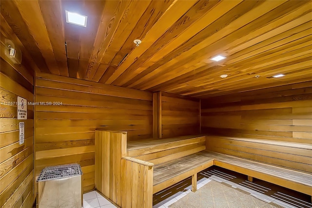 view of sauna with wood walls, tile patterned floors, and wooden ceiling