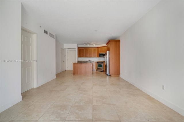 unfurnished living room with light tile patterned floors and sink