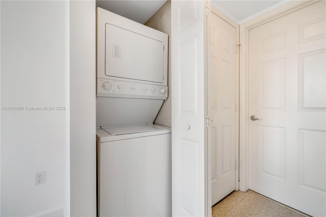 laundry area featuring stacked washer / drying machine