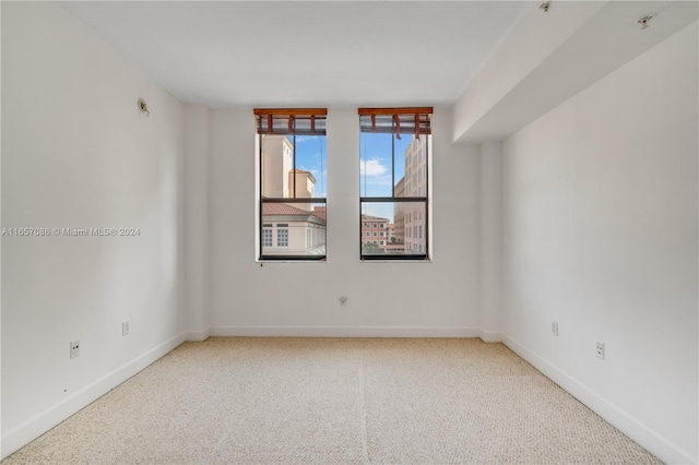 spare room featuring light carpet