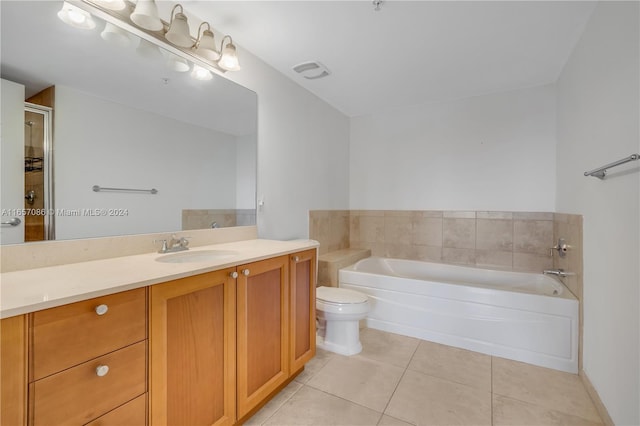 bathroom with tile patterned floors, a tub to relax in, toilet, and vanity