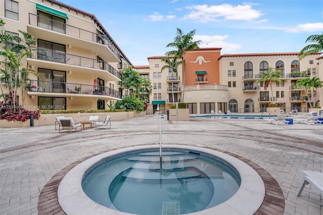 view of pool with a hot tub and a patio area