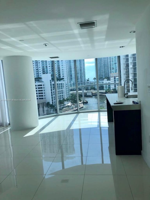 interior space with sink, expansive windows, and light tile patterned flooring