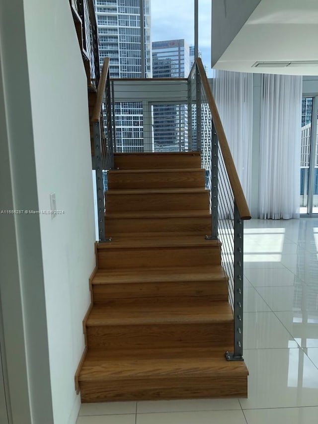 stairs with a wealth of natural light and tile patterned floors