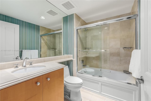 full bathroom featuring toilet, vanity, tile patterned floors, and enclosed tub / shower combo