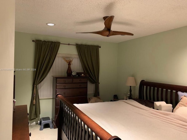 bedroom with a textured ceiling, ceiling fan, and carpet flooring