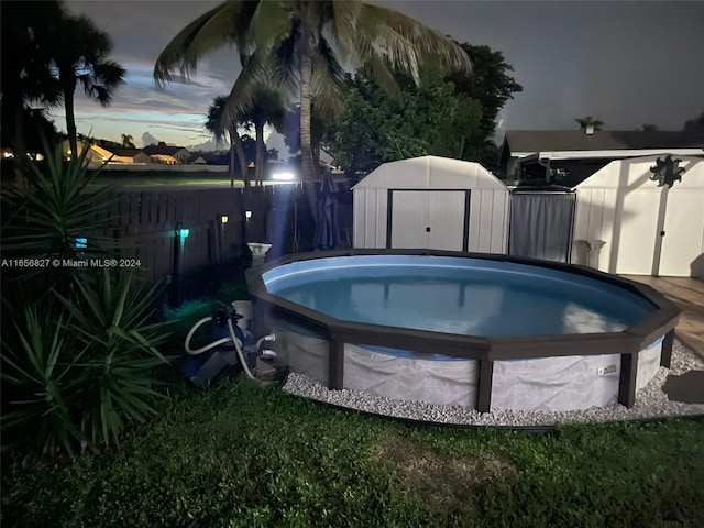 view of swimming pool featuring a storage unit and a hot tub