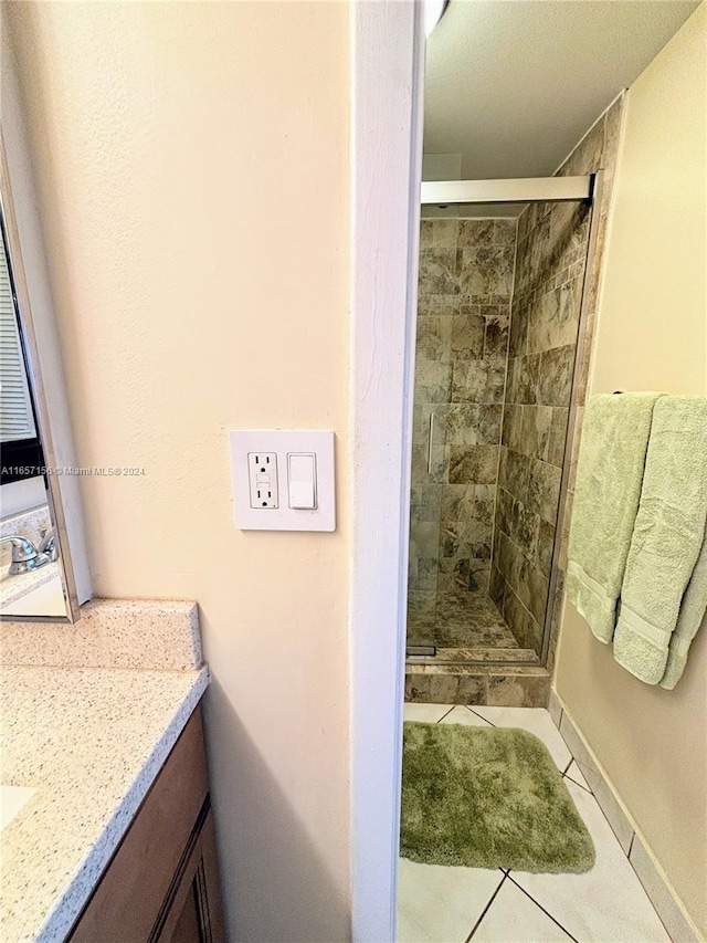 bathroom with tile patterned floors, an enclosed shower, and vanity