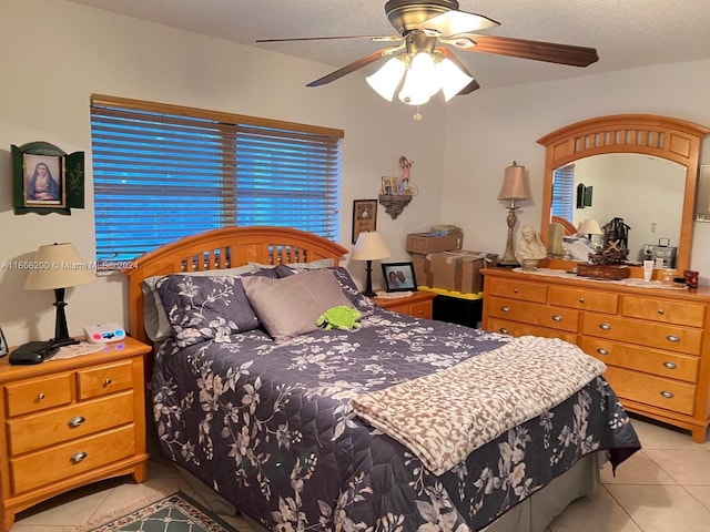 bedroom featuring ceiling fan, a textured ceiling, and light tile patterned flooring