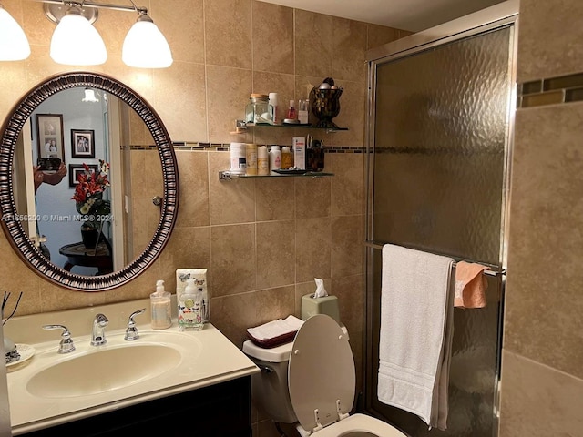 bathroom featuring vanity, toilet, walk in shower, and tile walls